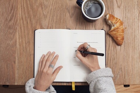 Person writing in notebook